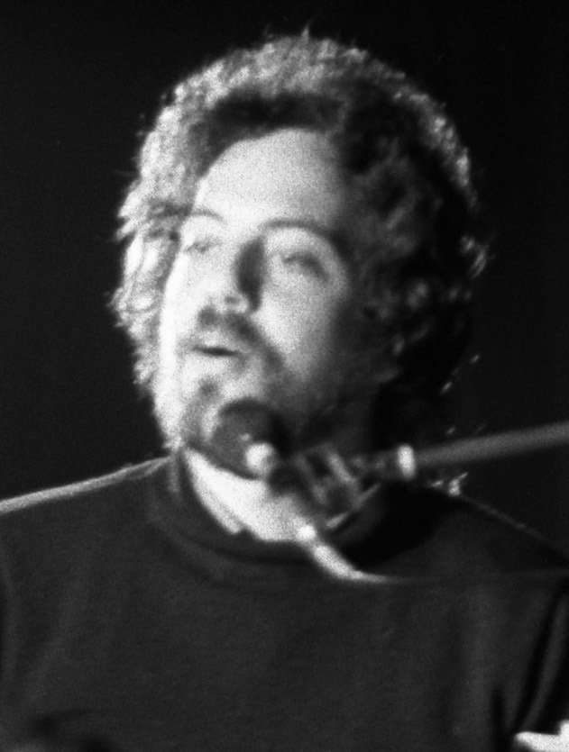 Close-up of Billy Joel singing at the piano in 1972; black and white photo.
